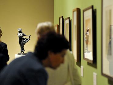 múzeumi képeket néz egy férfi