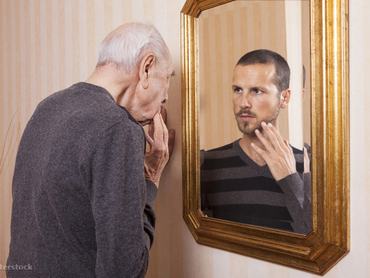 idős férfi áll a fiatalkori tükörképe előtt