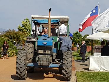 traktoron utazó emberek a mező szélén zászlóval