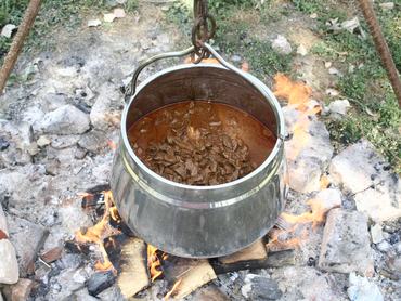 bogrács a tűz felett, benne fő az étel