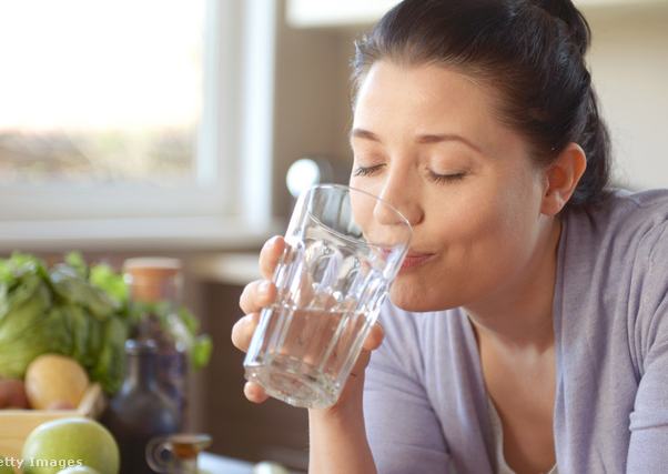 nő vizet iszik egy pohárból