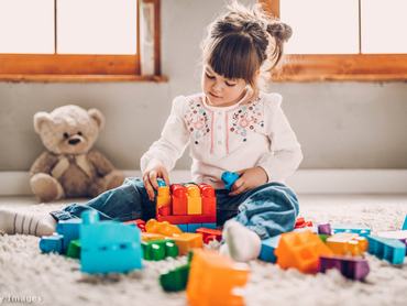 kislány játszik a szőnyegen