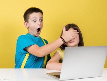 Kisfiú döbbent arcot vég és befogja a képernyőt néző kislány szemét