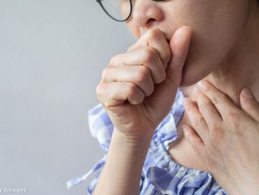 Egy nő az öklébe köhög