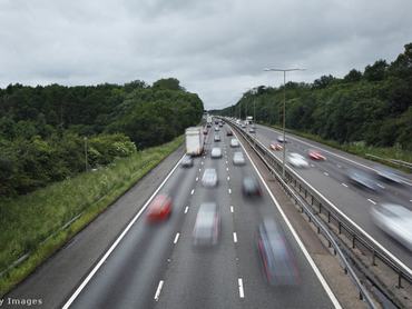 gyorsan haladó autók sziluettje az autópályán
