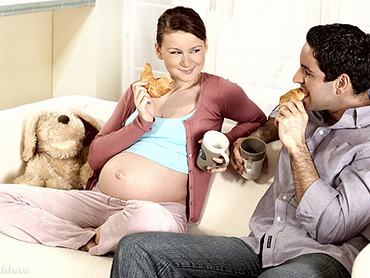 Kanapén ül a terhes nő és a férje