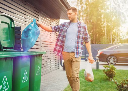 szemetet visz ki egy férfi a hulladékgyűjtő edényekbe