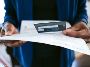 plasztikkártyát néz egy férfi