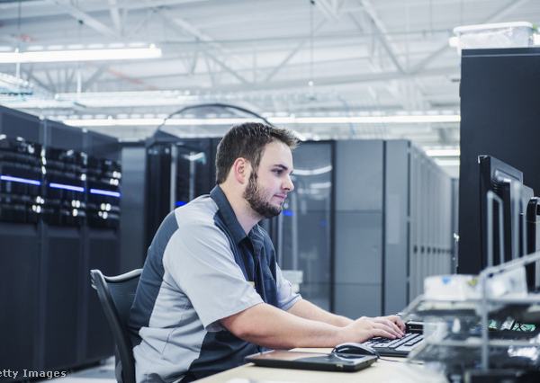 Informatikusként dolgozó férfi ül a számítógép mögött