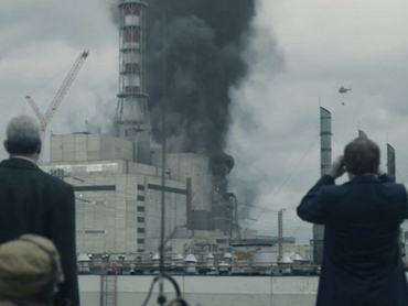 két ember a csernobili atomerőmű felrobban reaktora előtt, füst tör elő