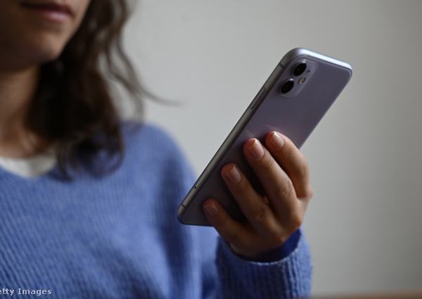 Egy nő mobiltelefont tart a kezében