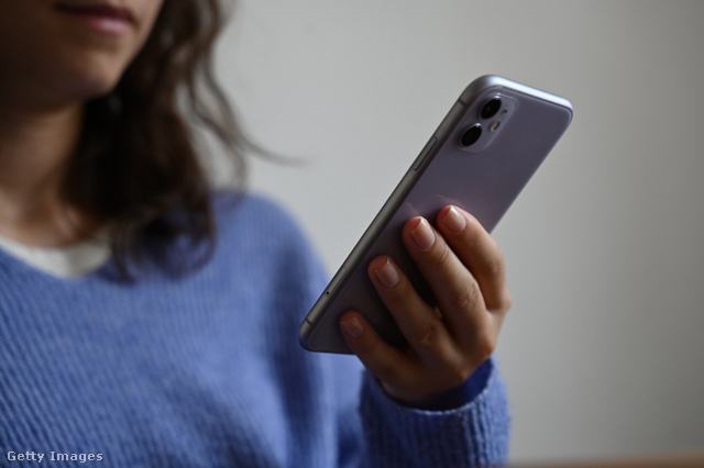 Egy nő mobiltelefont tart a kezében
