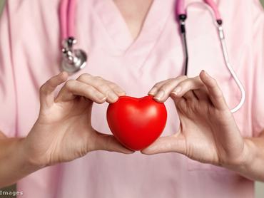 Egy női orvos egy szívet jelképező tárgyat tart a kezében