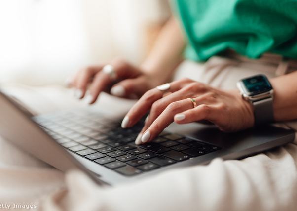 Egy női kéz a laptop billentyűzetén munka közben