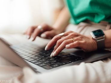 Egy női kéz a laptop billentyűzetén munka közben