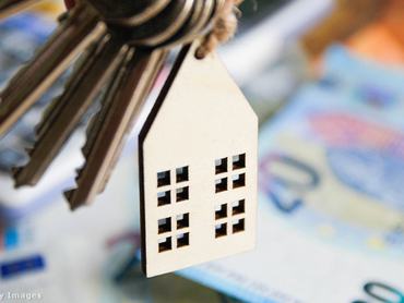 Ház alakú kulcstartó szimbolizálja az ingatlan-adásvételt