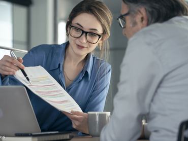 Egy szerződést mutató nő ügyfelével