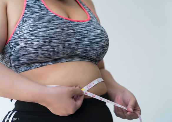 Nő a hasát méri egy mérőszalaggal