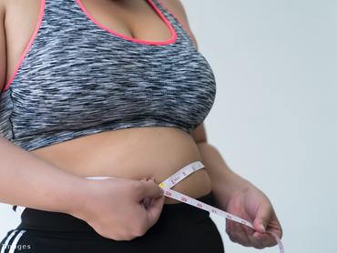 Nő a hasát méri egy mérőszalaggal