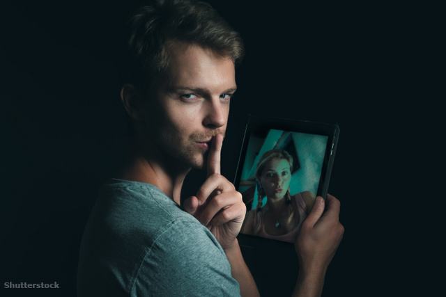 Egy férfi egyik kezében tablettel, a másikkal csendet mutat