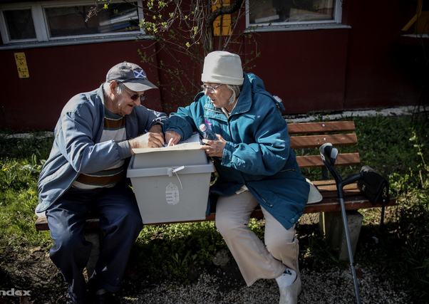 mozgóúrna mellett ül egy férfi és egy nő