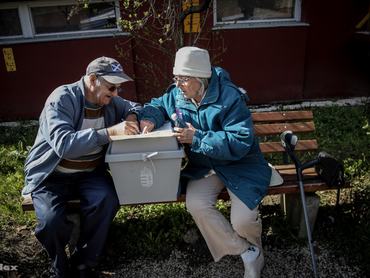 mozgóúrna mellett ül egy férfi és egy nő