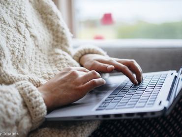 egy np a laptopján dolgozik a szobában