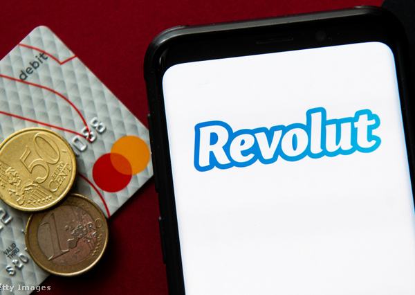 Revolut a mobiltelefon kijelzőjén, bankkártya és aprópénz