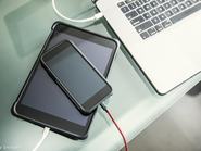 egy telefon, egy laptop és egy ipad az asztalon