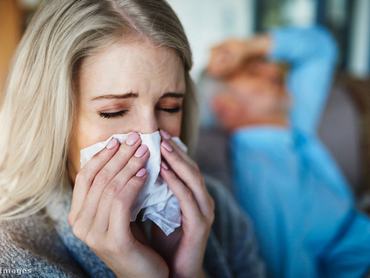 Fiatal nő zsebkendőbe tüsszent