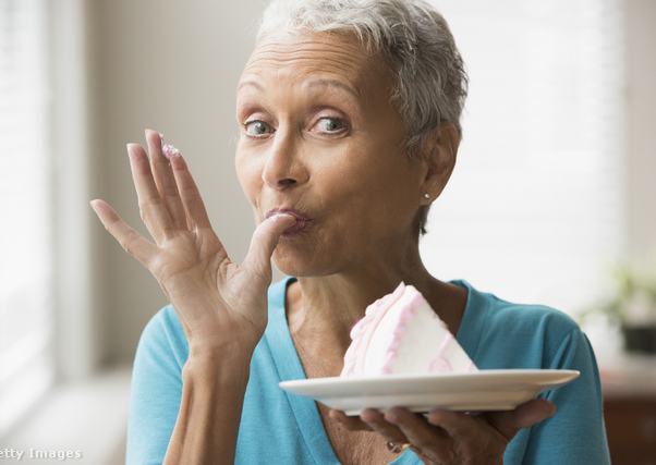 Idősebb nő tortát kóstol