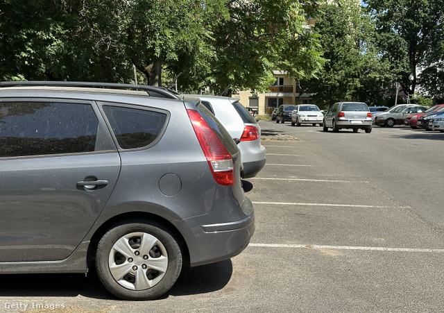parkoló autók hátulja rendezett sorban egy aszfaltozott parkolóban