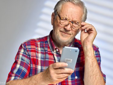 telefon szemuveges férfi keze