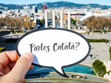 closeup of the hand of a caucasian man showing a speech bubble with the question parles catala?, do you speak Catalan written in Catalan, at Montjuic Hill, in Barcelona, Spain