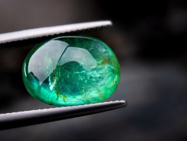 The emerald gemstone jewelry photo with dark lighting background.