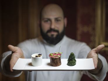 Egy fine dining étterem séfje egy tányér ételt tart