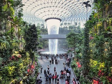 Jewel Changi Airport, Singapore - 5th August, 2019: Visitors tour around the Rain Vortex inside the Jewel area at Changi Airport. It's the world's tallest waterfall at 130 ft in height and surrounded by a four-storey terraced forest. The Jewel complex and waterfall was designed by Moshe Safdie.