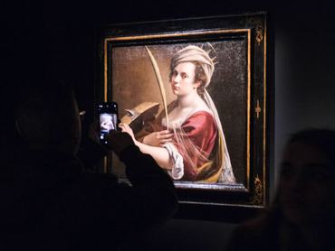 NAPLES, ITALY - 2022/12/03: A visitor photographs a painting called "self Portrait as Saint Catherine of Alessandria" by italian painter Artemisia Gentileschi (1593-1653) property of the National Gallery of London, during the opening, dedicated to press, of exhibition "Artemisia Gentileschi at Naples " inside Gallerie d'Italia museum in the center of Naples, southern Italy. (Photo by Mario Laporta/KONTROLAB/LightRocket via Getty Images)