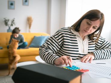 a szülő számológépet használ háttérben a gyerekkel