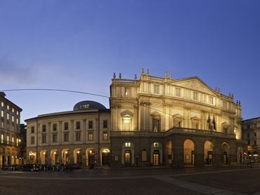 Spotlights illuminating the iconic facade of the Teatro alla Scala, the shops of Via Manzoni and the square of the Piazza della Scala under deep blue dusk skies in the heart of Milan, Italy. ProPhoto RGB profile for maximum color fidelity and gamut.