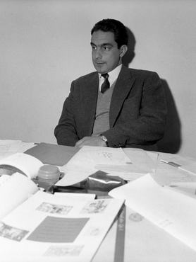 Italo Calvino, italian writer and Einaudi publishing company's associate, sits at his desk filled with paperwork. Turin (Italy), July 1959. (Photo by Emilio Ronchini/Mondadori via Getty Images)