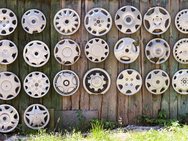 Fa kerítésre rögzített, régi, elhagyott műanyag dísztárcsák