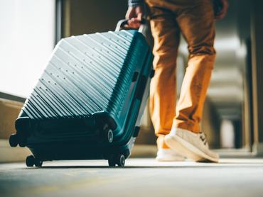 egy férfi bőröndjével a hotel folyosóján