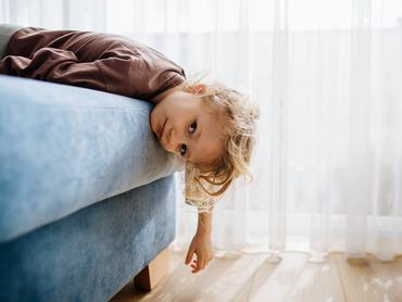 Bored little girl lying on the couch doing nothing.