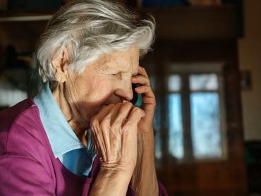 idős hölgy aggódó arccal telefonál