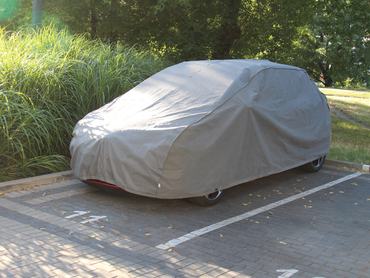Ponyvával letakart autó a parkolóban