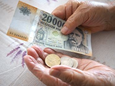 Idős nő kezében forint.