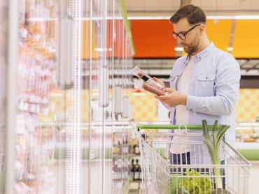 Egy férfi ellenőrzi a szupermarketben a megvásárolni kívánt hús címkéjét