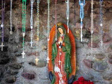 A Guadalupe-i Szűzanya szobra, rózsfüzérekkel az előtérben