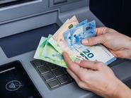 Egy kézpár eurót számol az ATM automata felett